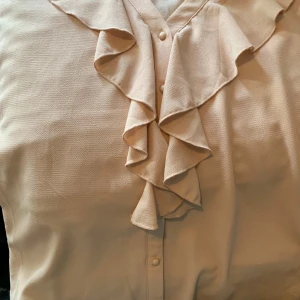 Blus - En kort armad blus med lite volanger vid kragen jätte fin till sommaren.