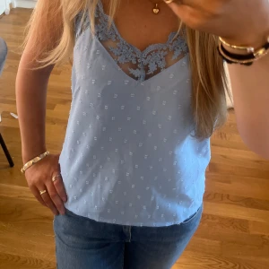 Ljusblå linnetopp med spetsdetaljer - Säljer en ljusblå linnetopp i storlek xs, axelbanden går även att justera. Toppen har fina spetsdetaljer upptill och detaljer på tyget. Perfekt för sommaren eller under en kofta på varmare dagar