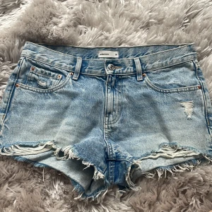 Ljusblå jeansshorts med fransar från gina - Säljer ett par ljusblå jeansshorts från Gina Tricot med slitna detaljer och fransig kant. De är i stolek 38 och säljer eftersom de är för stora för mig. Skulle säga att de är mid waist. Använda några gånger med de har inga defekter💗
