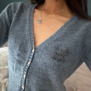 Blå kofta med v-ringning från odd& Molly - Mysig blå kofta med v-ringning och pärlemorfärgade knappar framtill. Tröjan är stickad och har långa ärmar, perfekt för lager-på-lager. Enkel och stilren design som passar till mycket.odd& Molly storlek XS 