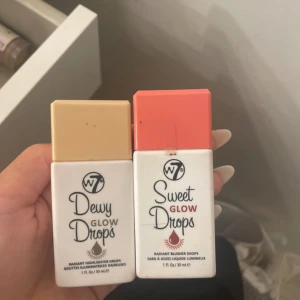 W7 Dewy Glow Drops & Sweet Glow Drops - Två flytande blush/highlighter drops från W7. Dewy Glow Drops har en beige-guldig nyans och Sweet Glow Drops har en persikorosa nyans. Kommer i smidiga flaskor med färgade lock, perfekta för att ge glow till kinderna.