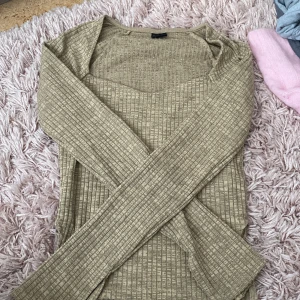 Beige ribbad långärmad tröja - Säljer en beige ribbad långärmad tröja med fyrkantig ringning. Tröjan har en mjuk och stretchig känsla, perfekt för lager-på-lager eller som den är. Passar till mycket och är enkel att styla.