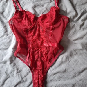 Röd spetsbody  - Säljer en röd body med spets. Egen lösning nertill