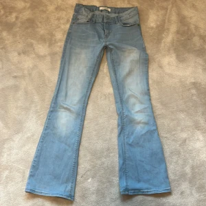 Ljusblå bootcut jeans från Lindex - Säljer ett par ljusblå jeans från Lindex i bootcut-modell. Jeansen har klassisk femficksdesign, normal passform och är tillverkade i denim. Perfekta för dig som gillar en retroinspirerad look. Det är en liten slitning på höger bakficka! Hör av er vid frågor❤️