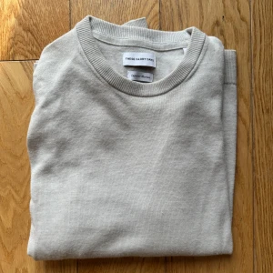 Beige stickad tröja från These Glory Days - Säljer en stilren beige stickad tröja från These Glory Days. Tröjan har rund halsringning och långa ärmar, perfekt för lager-på-lager. Enkel och klassisk design som passar till det mesta. Storlek M