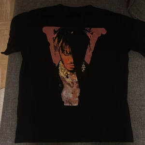 Svart t-shirt Juice WRLD Legends Never Die - Svart t-shirt med tryck av Juice WRLD på framsidan och texten 'Legends Never Die' samt 'Juice WRLD 999' på baksidan. T-shirten har normal passform och är kortärmad, perfekt för dig som gillar streetwear och musik. (F4k3)