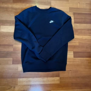 Svart sweatshirt från Nike - Säljer en svart sweatshirt från Nike med klassisk vit logga på bröstet. Den är använd en gång men den var för stor, storlek S men sitter mera som M. Skriv för mer bilder eller om du har funderingar