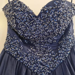 Marinblå långklänning med pärlor och snörning - Superfin balklänning som jag nu säljer för att den inte passade mig helt!✨Den passar nog alla olika storlekar eftersom den knyts där bak i ryggen, väldigt fint skick!