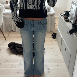 Ljusblå bootcut jeans med fickdetaljer - Säljer ett par ljusblå jeans med bootcut passform och snygga fickdetaljer både fram och bak. Jeansen har låg midja, de är menade att vara gripande men sitter såhär på mig som är 153🌟🌟
