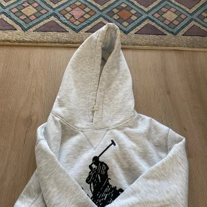 Grå hoodie från Ralph Lauren - Säljer en Ralph lauren hoodie. Använd ett fåtal gånger. Storlek M, jag e 175 och den sitter bra men lite stor i axlarna. Priset är inte hugget i sten 