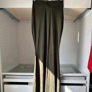 Olivgröna lång kjol med hög midja - Säljer en lång kjol som är olivgrön med fint sval. Den är i stolek XS och är stretchig. Är 174 och den är super bra längd på mig 