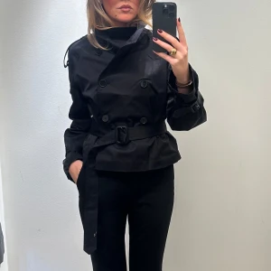 Svart trenchcoat med bälte - Säljer denna svarta populära trenchcoaten från H&M som är slutsåld. Jackan är som ny, använd 2 gånger. Storlek M 💌