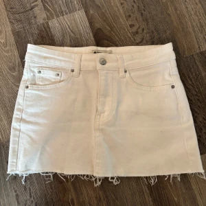 Vit jeanskjol från Gina tricot - Vit jeanskjol från Gina tricot. En liten fläk upp till vänster på framsidan