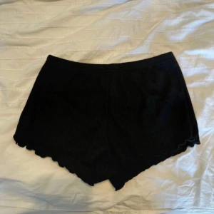 Svarta shorts. - Svarta shorts. Mjuka och stretchiga, perfekta för en avslappnad stil. Tillverkade i 65% polyester och 35% viskos. Midjan är elastisk för extra komfort. Den är i storlek S men den är ganska liten i storlek så skulle säga att det är XS. Den är aldrig använd helt ny fast utan prislapp.
