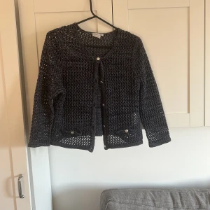 Mörkblå stickad kofta med knappar - Snygg mörkblå stickad kofta med långa ärmar och knappar framtill. Perfekt för lager-på-lager och ger en stilren look. Passar bra till både jeans och kjol.