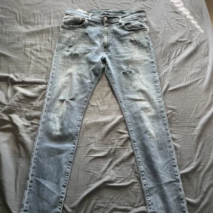 Mörkblå Levis jeans - Mörkblå Levis jeans med feta slitningar. De är i mycket bra skick pris kan självklart diskuteras