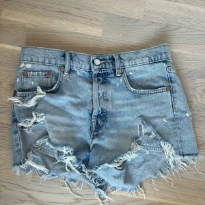 Blå jeansshorts med fransar - Ett par blåa jeansshorts från zara.