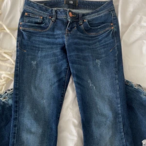 Blå jeans från LTB - Snygga blå jeans från LTB med klassisk femficksdesign och slitna detaljer. Strl 27/30