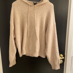 Beige hoodie från Lindex - Mysig beige hoodie från Lindex i storlek M. Perfekt för kyliga dagar med sin mjuka och bekväma passform. Den har en klassisk huva och långa ärmar, vilket gör den idealisk för både avslappnade och stilrena outfits.