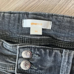 Grå jeans från Gina Tricot - Änvända ganska många gånger men fortfarande i väldigt bra skick. Säljer eftersom dom är förstora i benen och lite för korta för mig. Resor i midjan. Lite slitna allra längst ner. Storlek 164. Utsvängda jeans.