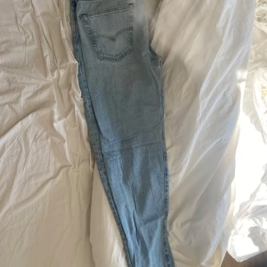 Levis jeans 501 - Snygga ljusblå jeansbyxor med klassisk femficksdesign. De har en rak passform och är perfekta för en avslappnad stil. Byxorna har en knappgylf och är tillverkade i ett slitstarkt denimtyg.            Som nya, använda max 10 gånger, ny pris 1200kr säljer för 500kr.   Storlek W33 L34