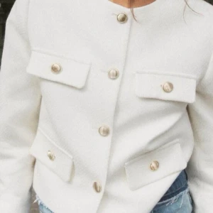 Vit kavaj från Zara - Elegant vit kavaj från Zara med guldknappar och fyra fickor framtill. Den har en klassisk design med rund hals och långa ärmar. Använd fåtal gånger🩷