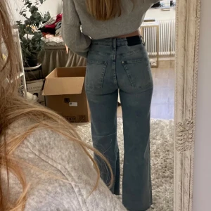 Blå wide highwaist jeans - Säljer ett par blå jeans med wide passform och hög midja. Jeansen har raka ben och ankellängd, klassisk femficksdesign och är tillverkade i denim. Perfekta för dig som gillar en avslappnad och trendig stil.
