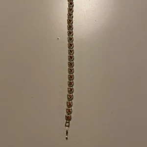 Silverfärgat armband med hjärtan - Säljer ett silverfärgat armband med länkar formade som små hjärtan. Armbandet har en klassisk låsning och en elegant design som passar perfekt till att lyfta vilken outfit som helst.stor runt hand vristen 