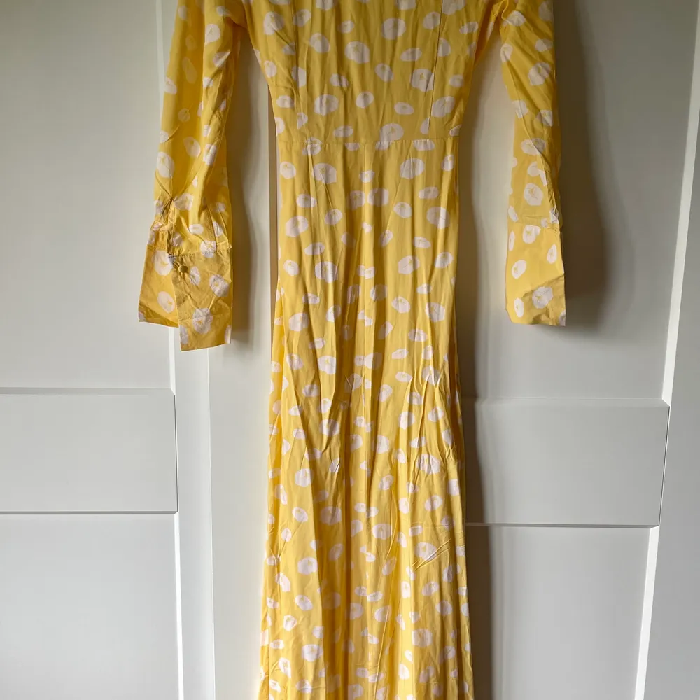Superfin klänning från NAKD i storlek 34. Klänningen är i en fin gul färg med vita blommor på, klänningen är v ringad och har ett band i midjan som man kan knyta.  Aldrig använd då den är för liten för mig.. Klänningar.