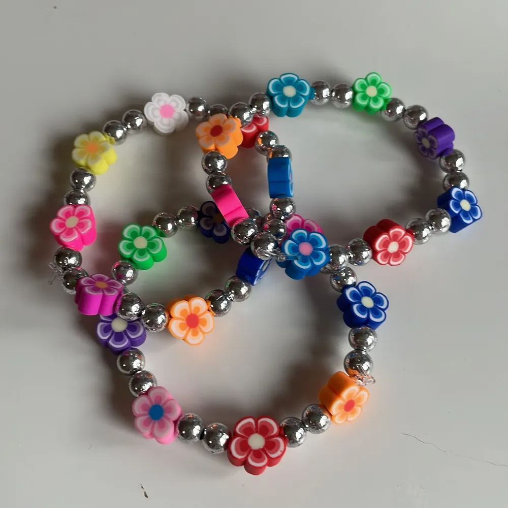 Blommigt armband med olika färger! Silvriga pärlor med blommor i olika färger!  Frakt: 15kr ej spårbart! Tar Swish!. Accessoarer.