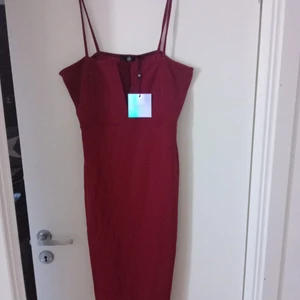Missguided klänning - 💥 Ny klänning från Missguided. Klänningen är endast testad så lappar finns kvar!  Vinröd, figurnära klänning med stretchigt tyg samt urringning.  Tyvärr passar den ej mig då den var för stor, jag har strl L/173cm. 