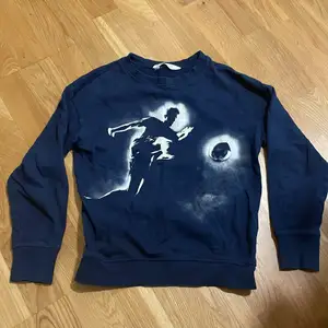 Marinblå sweatshirt med tryck från H&M. För pojkar. Storlek: 134/140