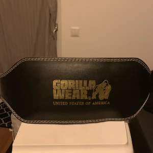 Gorilla Wear Gymbälte - Gymbälte från Gorilla Wear. Köpt i MM Sports Odenplan. Storlek S/M. Ordinariepris 5-600, kommer ej ihåg exakt. Använd därav lite missfärgning på kudden men funkar precis som vanligt, jättebra kvalité på bältet. Möts upp annars står köpare för frakt!