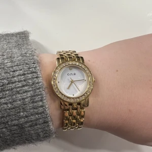 Guld klocka - Super fin guldig klocka från O.n.e. Batteriet behövs bytas. Storlek på bandet är 17,5-20,5 cm. Då det går att förlänga. Säljer för 80kr. GRATIS FRAKT 