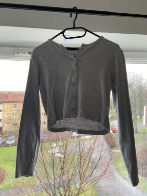 Långärmad med knappar - Supersöt tröja som aldrig är använd. Småribbad. Tack vare knapparna funkar den även utmärkt som en kofta.