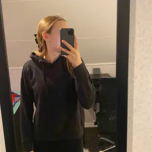 En svart basic hoodie som är för kort för mig