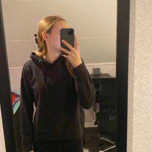 Hoodie - En svart basic hoodie som är för kort för mig