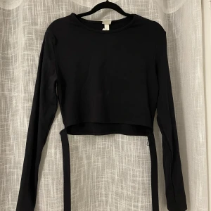 Svart långärmad - Svart croppad långärmad ifrån hm med knytdetalj. Aldrig använd. Frakt tillkommer!❤️