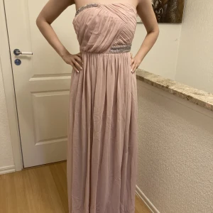 Rosa långklänning - Enkel och elegant i modellen. Skickar fler bilder vid intresse. Som ny men behöver strykas lite.