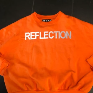 ISTAY sweatshirt - Klar orange färg med reflextryck. Skön och någorlunda tunn, mjuk insida  Strl. M