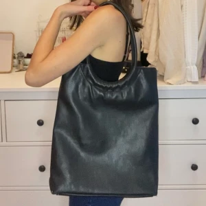 svart totebag väska läder - Superfin svart handväska, köpt secondhand. Känns som läder men är inte helt säker, lite sliten i botten. Ficka med dragkedja utanpå och en inuti🤎 Möts i slussen eller postas, köp nu är på