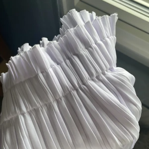 Plisserad kjol - NA-KD - Plisserad kjol från NA-KD i nyskick, aldrig använd. Normal passform. Kjolen är vit, men drar åt det lila hållet. 