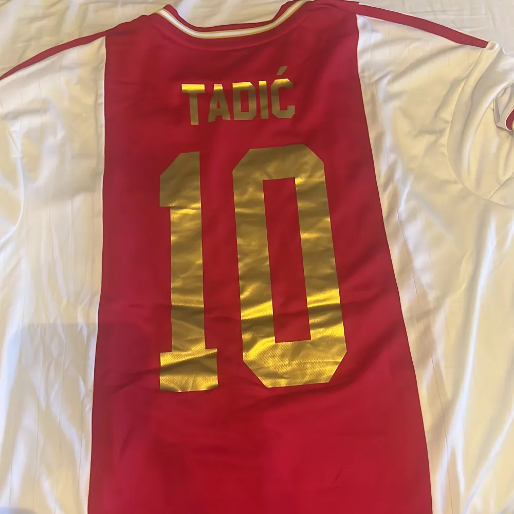 Säljer denna Ajax tröja som inte är använd, med Tadic 10 på ryggen . T-shirts.