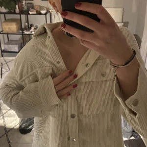 Vårjacka/overshirt  - En perfekt overzise vårjacka/tjockare skjorta i Manchester. Säljer då den inte kommer till användning mer. Den är använd ett antal gånger, men i fint skick utan slitage/missfärgningar. Färgen är vit/beige. Nypris är 500kr. Priset är inklusive frakt! 