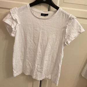 T shirt med volanger - Vit t shirt från kappahl, stl S. Volanger på ärmarna. Kom privat för fler bilder eller frågor och frakten är 40 kr
