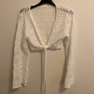 Vit stickad topp - En vit stickad topp som funkar perfekt över en klänning nu till sommarn.