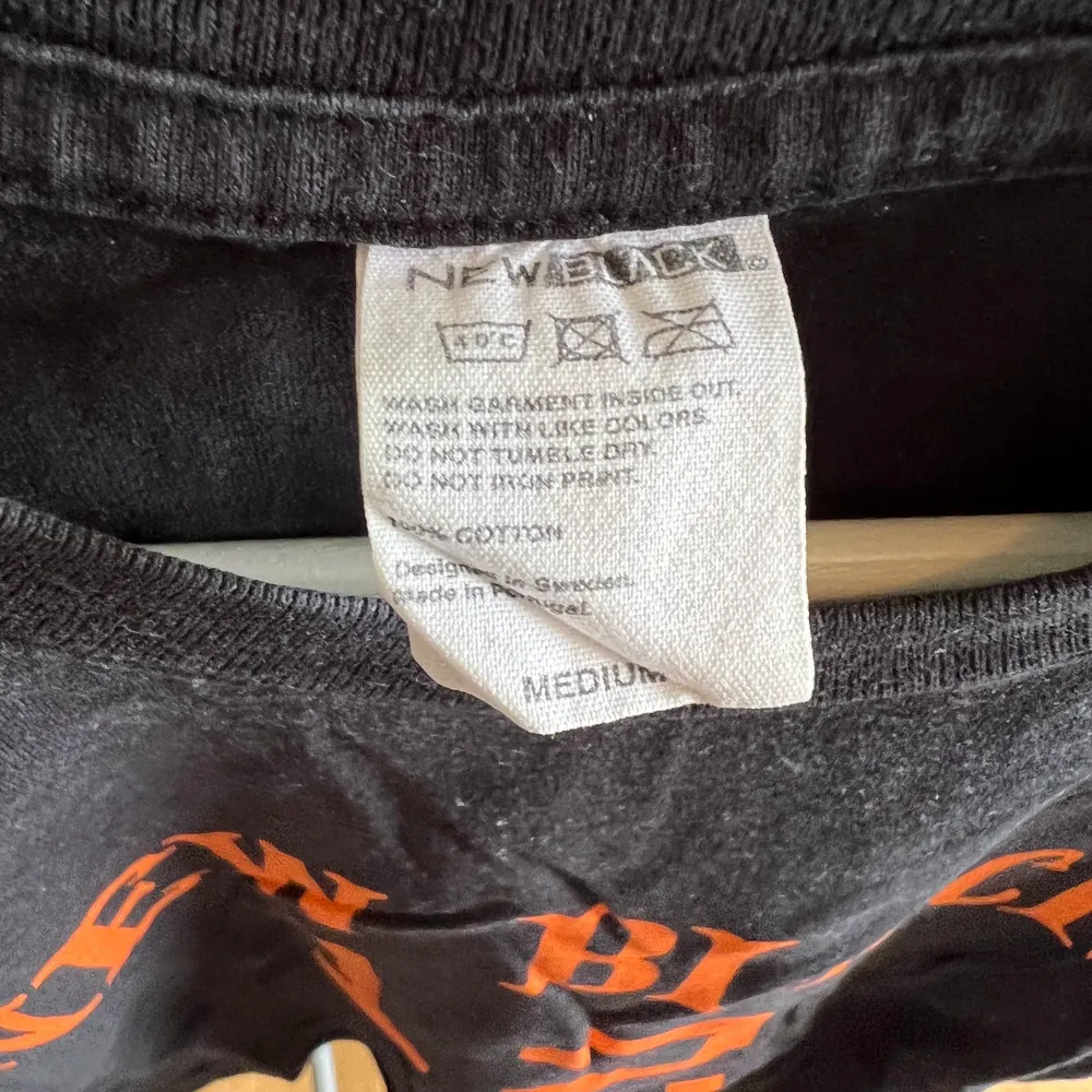 New black t shirt med orange text. Storlek medium. Mycket skönt bomulls tyg. . T-shirts.