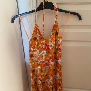 Klänning från Bershka i orange/blommigt mönster, köpt förra sommaren och bara använd ett fåtal gånger. Strl M