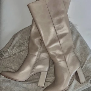 Beige knähöga stövlar - Dom perfekta beige knähöga stövlarna med klack. Helt oanvända med prislapp kvar. Storlek 38, passar även 37  💞
