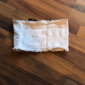 vit topp - en söt liten vit topp, osäker på storlek men jag hoppas man kan tyda lappen litegrann. inte använd så mycket.